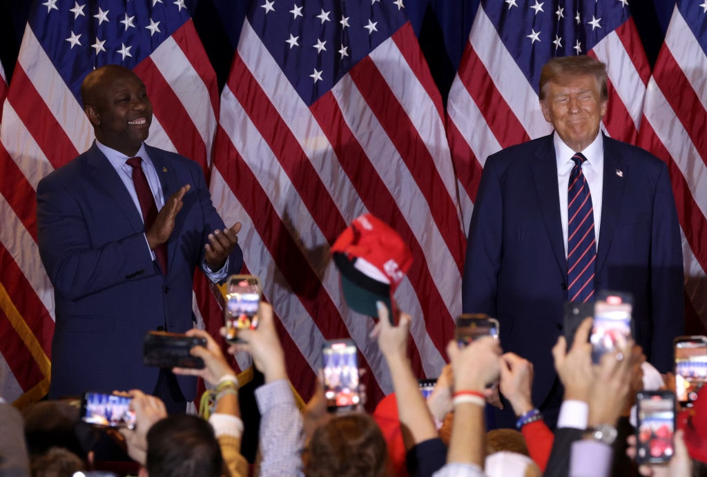 Donald Trump Holds New Hampshire Primary Night Event In Nashua, New Hampshire NASHUA, NEW HAMPSHIRE - JANUARY 23: U.S. Sen Tim Scott (R-SC) applauds alongside Republican presidential candidate and former U.S. President Donald Trump during Trump's primary night rally at the Sheraton on January 23, 2024 in Nashua, New Hampshire. New Hampshire voters cast their ballots in their state's primary election today. With Florida Governor Ron DeSantis dropping out of the race Sunday, former President Donald Trump and former UN Ambassador Nikki Haley are battling it out in this first-in-the-nation primary. (Photo by Alex Wong/Getty Images)